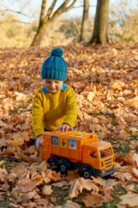 child playing with toy garbage truck