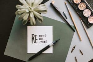 sticky note on table that reads reduce, reuse, recycle